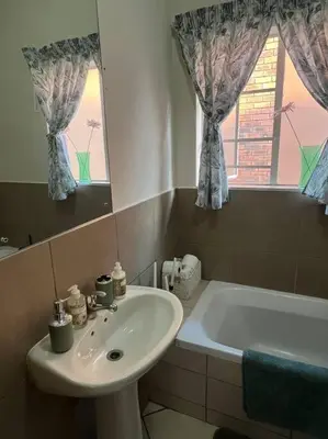 a bathroom with a sink and a bath tub at Homie my home in Centurion