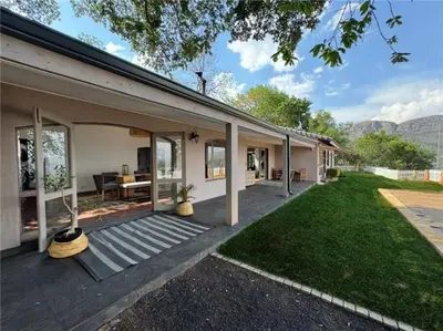 a house with a wooden porch and a yard at Casa Galetti in Hartbeespoort