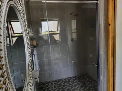 a shower with a glass door in a bathroom at Kwena Guesthouse in Groblersdal