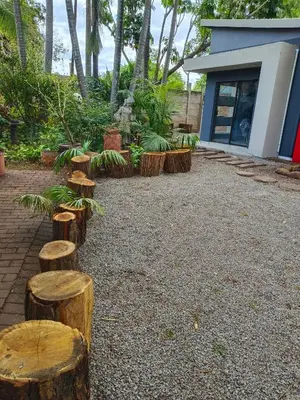 a group of logs sitting in front of a building at Kwena Guesthouse in Groblersdal