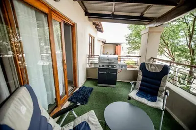 a screened in porch with two chairs and a stove at Luxuriously finished 2 bedroom in Midrand