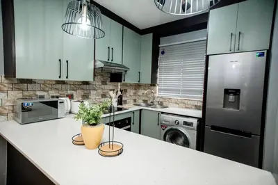 a kitchen with green cabinets and a counter with plants on it at Luxuriously finished 2 bedroom in Midrand