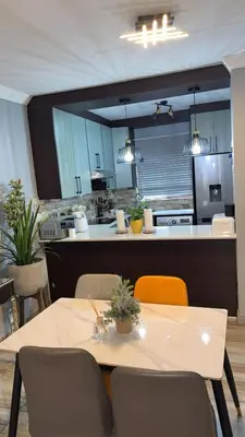 a dining room with a table and a kitchen at Luxuriously finished 2 bedroom in Midrand