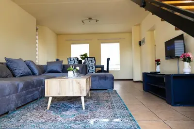 a living room with a couch and a coffee table at Pristine in Centurion