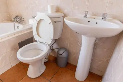 a bathroom with a toilet and a sink at Pristine in Centurion