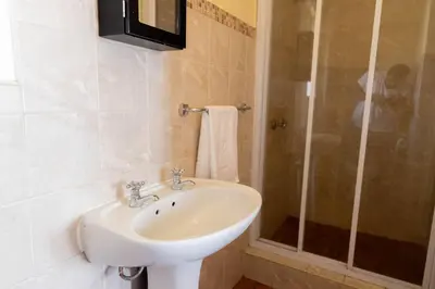 a bathroom with a sink and a shower at Pristine in Centurion