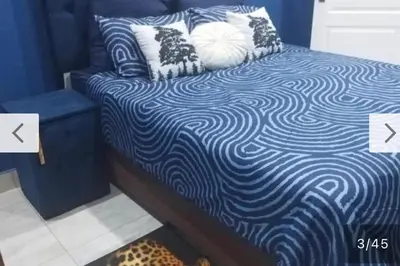 a blue and white bed with pillows on it at Budais guest lodge in Kempton Park