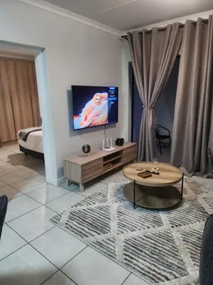 a living room with a tv and a coffee table at Cozy home at The Blyde in Pretoria