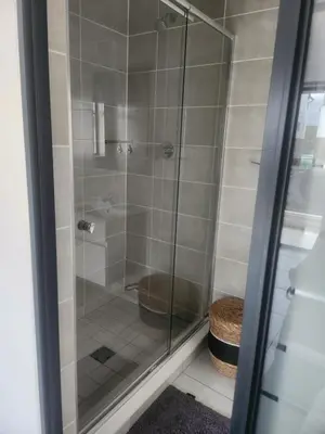 a bathroom with a glass shower with a toilet at Cozy home at The Blyde in Pretoria
