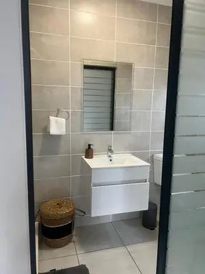 a bathroom with a sink and a mirror and a toilet at Cozy home at The Blyde in Pretoria