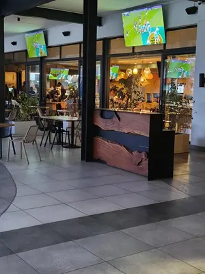 a restaurant with tables and chairs in a building at Cozy home at The Blyde in Pretoria
