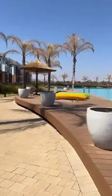 a row of surfboards on a table next to a pool at Cozy home at The Blyde in Pretoria