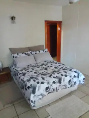 a black and white bed in a bedroom at Villa La Corrie GUEST LODGE in Steelpoort