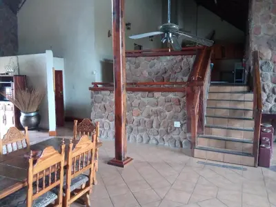 a room with two wooden benches and a stone wall at Villa La Corrie GUEST LODGE in Steelpoort