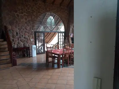 a dining room with a table and chairs in a building at Villa La Corrie GUEST LODGE in Steelpoort