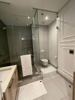 a bathroom with a glass shower and a toilet at El Mayor Deluxe Suite MENLYN MAINE in Pretoria