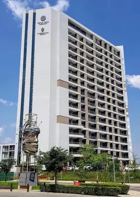 a large white building with a sign in front of it at El Mayor Deluxe Suite MENLYN MAINE in Pretoria