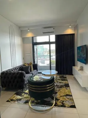 a living room with a couch and a table at El Mayor Deluxe Suite MENLYN MAINE in Pretoria