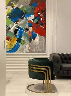 a green chair in a room with a painting at El Mayor Deluxe Suite MENLYN MAINE in Pretoria