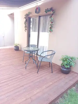 a patio with a table and chairs on a deck at Hoovers Nest in Pretoria