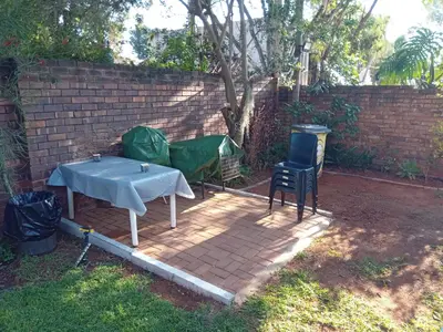 a table and a green tent next to a brick wall at Hoovers Nest in Pretoria