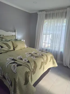 a bedroom with a bed with a blanket with birds on it at Hoovers Nest in Pretoria