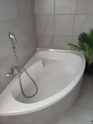 a white bath tub with a hose in a bathroom at Hoovers Nest in Pretoria