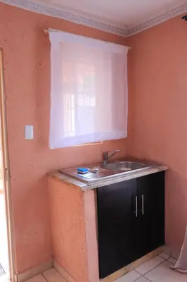 a kitchen with a sink and a window at Thenjwas Sleep-Over Lodge in Nelspruit