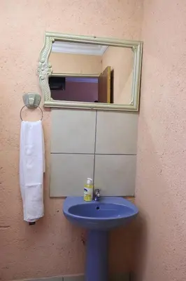 a bathroom with a blue sink and a mirror at Thenjwas Sleep-Over Lodge in Nelspruit