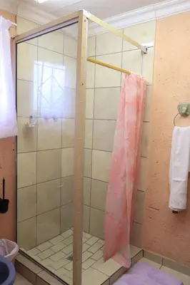 a shower with a glass door in a bathroom at Thenjwas Sleep-Over Lodge in Nelspruit