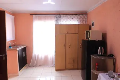 a kitchen with a large window and a refrigerator at Thenjwas Sleep-Over Lodge in Nelspruit