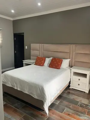 a bedroom with a bed with two pillows on it at Luxury Escape OR Tambo International in Kempton Park