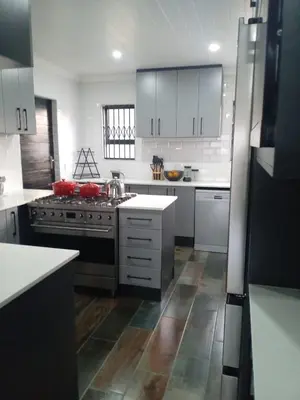 a kitchen with white cabinets and a stove top oven at Luxury Escape OR Tambo International in Kempton Park