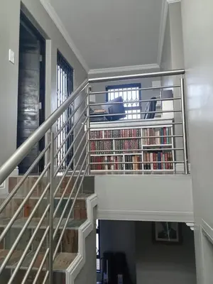 a spiral staircase with a book shelf filled with books at Luxury Escape OR Tambo International in Kempton Park
