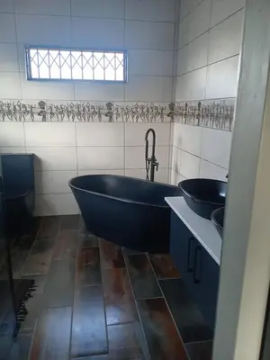 a bathroom with two sinks and a tub and a window at Luxury Escape OR Tambo International in Kempton Park