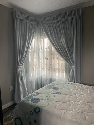 a bedroom with a bed and a window with curtains at Luxury Escape OR Tambo International in Kempton Park