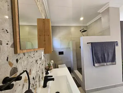 a bathroom with a sink and a mirror at Cranes Nest Guest House in Pretoria