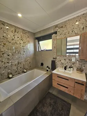 a bathroom with a tub and a sink at Cranes Nest Guest House in Pretoria