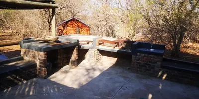 an outdoor patio with a bench and a building at Lions Gate in Marloth Park