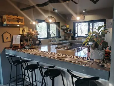 a kitchen with a counter with stools around it at Lions Gate in Marloth Park