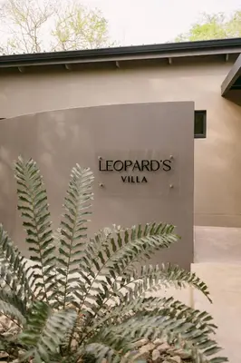 a sign for leopards villa on the side of a building at Leopard's Villa, Marloth Park in Marloth Park