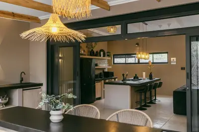 a kitchen with a table and chairs and a chandelier at Leopard's Villa, Marloth Park in Marloth Park