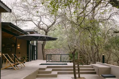 a patio with stairs and an umbrella on a house at Leopard's Villa, Marloth Park in Marloth Park