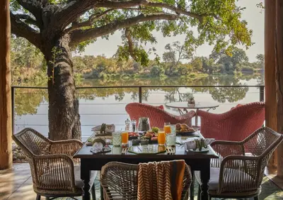 a table with food and chairs on a patio with a tree at Royal Malewane in Thornybush Game Reserve