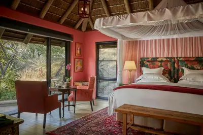 a bedroom with a bed and a table and chairs at Royal Malewane in Thornybush Game Reserve