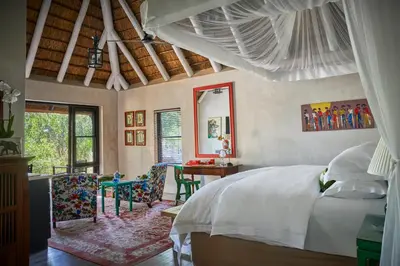 a bedroom with a bed and a table and chairs at Royal Malewane in Thornybush Game Reserve