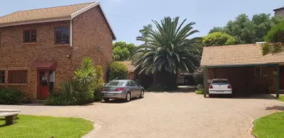 a car parked in a driveway next to a house at Jolly Suites in Midrand