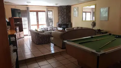 a living room with a couch and a pool table at Jolly Suites in Midrand