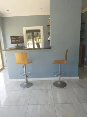 two chairs in front of a blue wall with a mirror at Budias Guesthouse B&B in Kempton Park