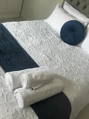a bed with towels and a blue pillow on it at Safaya Inn in Kempton Park
